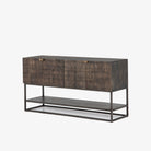 Four hands furniture brand Kelby media console with iron base and four carved doors with square brass pulls on a white background