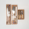 Assortment of Laguiole serving sets in wood boxes on a white background