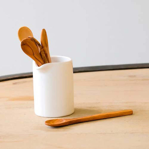 Solid olivewood jam spoon inside a white ceramic pitcher