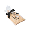 Monogramed maple cheese board with letter 'M' engraved and a stainless cheese knife wrapped in a cellophane sleeve on a white background