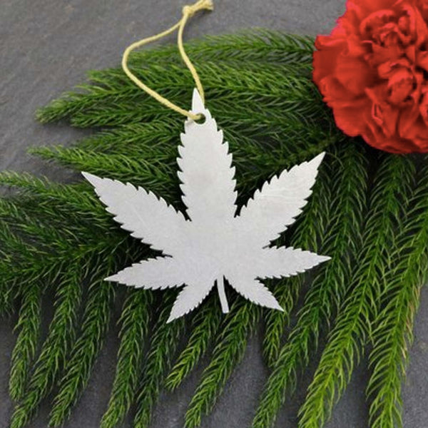 Brushed alumunim metal leaf ornament on a green background