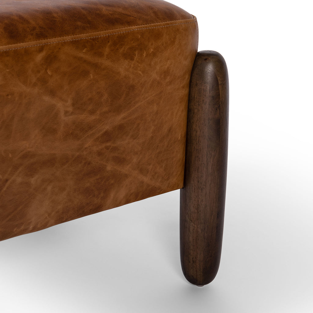 Close up of wood legs on Square leather 'Oaklynn' ottoman by four hands furniture with oversized round wood legs  on a white background
