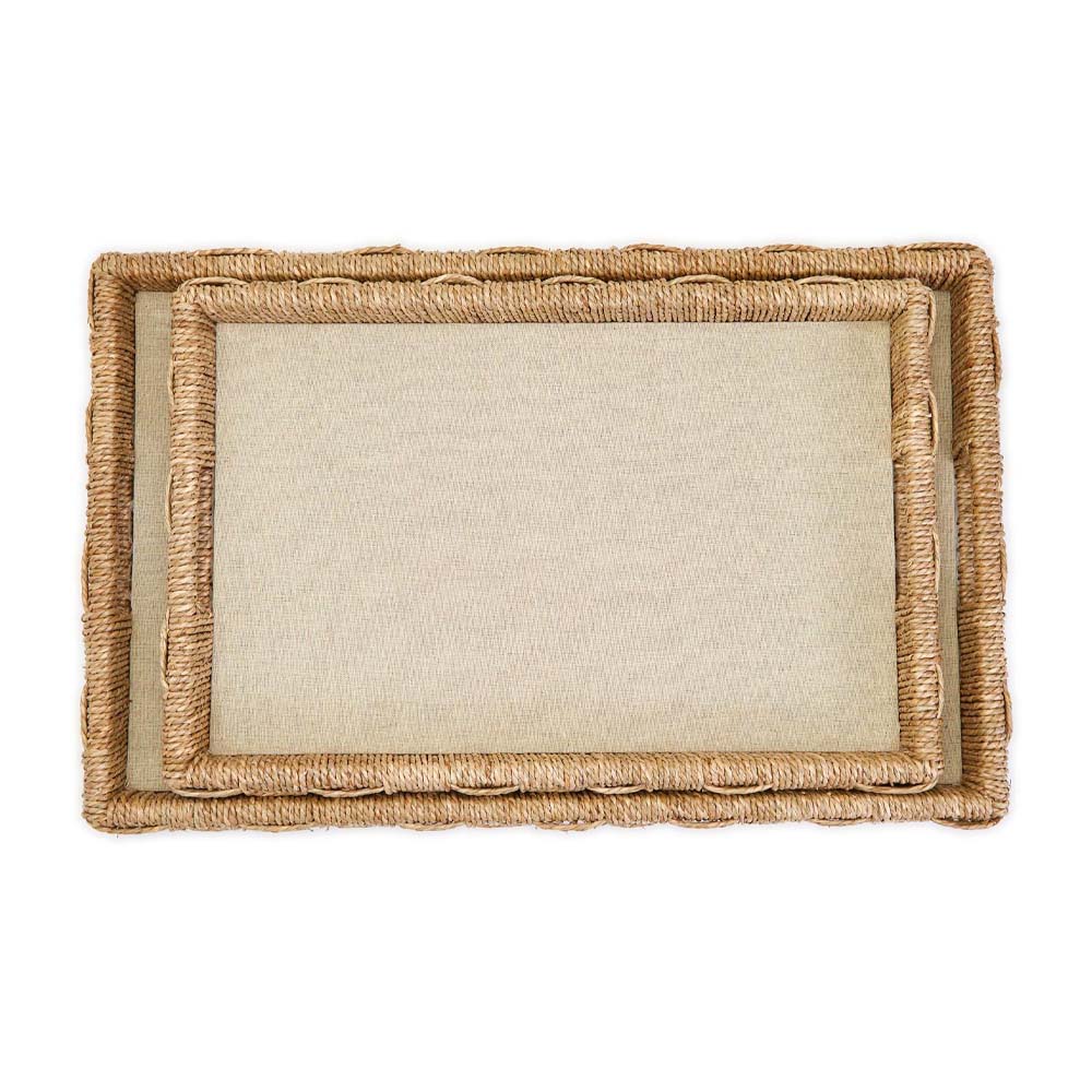 Two rectangular trays with woven seagrass and cotton surface stacked and seen from above on a white background