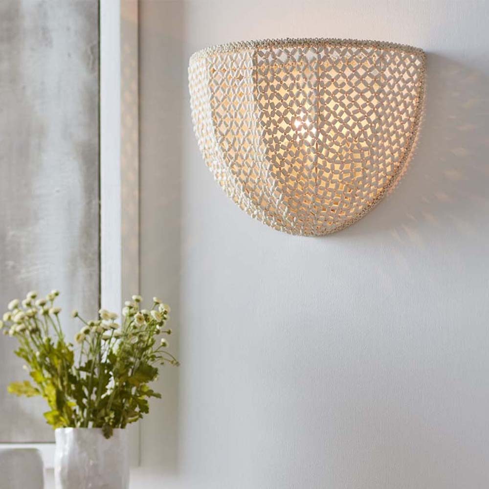 Ivory coco beads Palecek Quinn Sconce hanging on a white wall