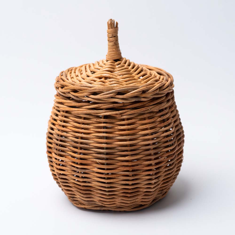 Small natural wicker basket with lid on a white background