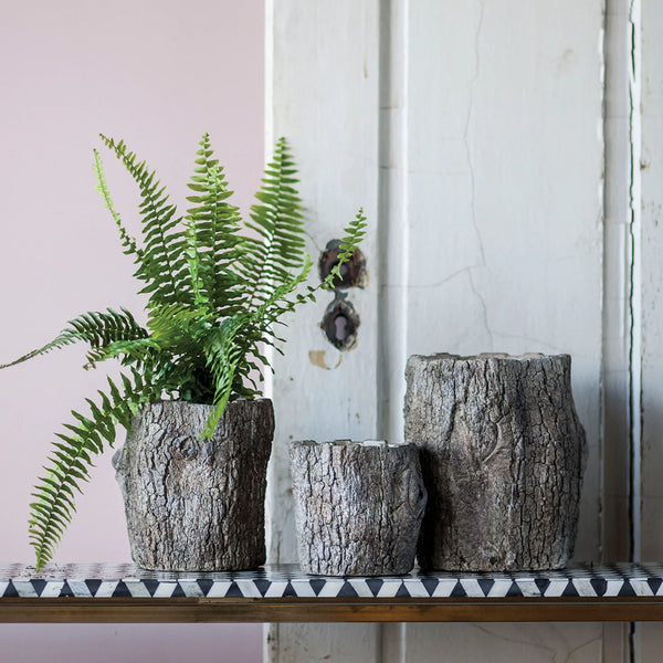 Faux bois log planters on a shelf with ferm