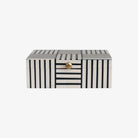 Black and white block stripe box with gold knob on lid on a white background