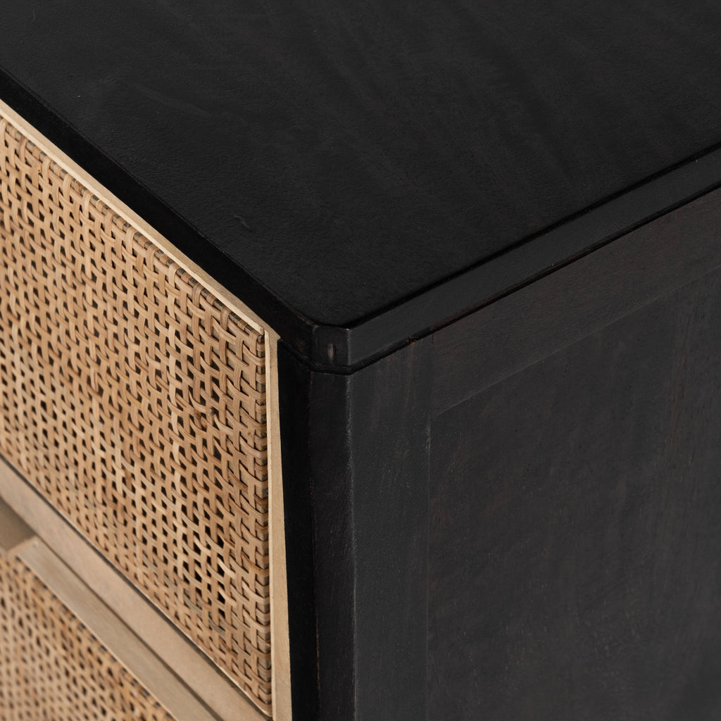 Close up of 'Sydney' Six drawer dresser by Four Hands Furniture with cane drawer fronts and mango wood pulls with black stained mango wood exterior on a white background