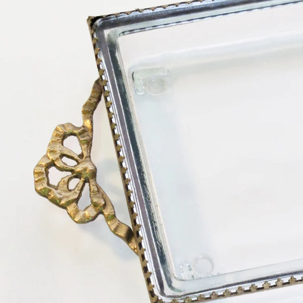 Glass tray with metal brass scallop edging and decorative metal bow on end