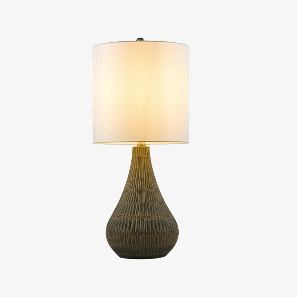 Gray glazed ceramic table lamp with white linen shade on a white background