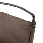 Four hands brand wharton chair with black iron frame and dark brown leather seat on a white background