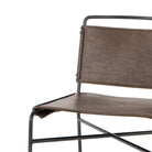Close up of Four hands brand wharton chair with black iron frame and dark brown leather seat on a white background