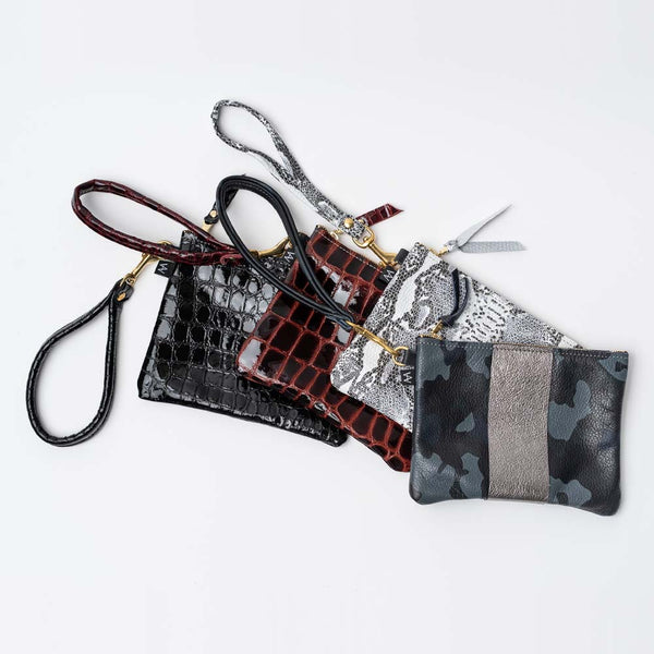 Assortment of Addison West leather patterned and embossed wristlets on white background