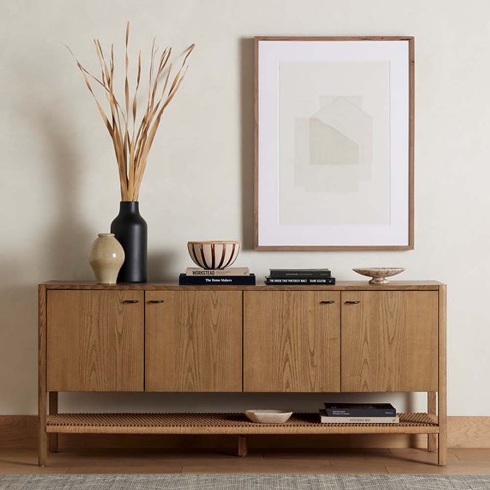 Wood four door 'Zuma' sideboard with shelf underneath by four hands furniture in a room with wood floor and cream walls