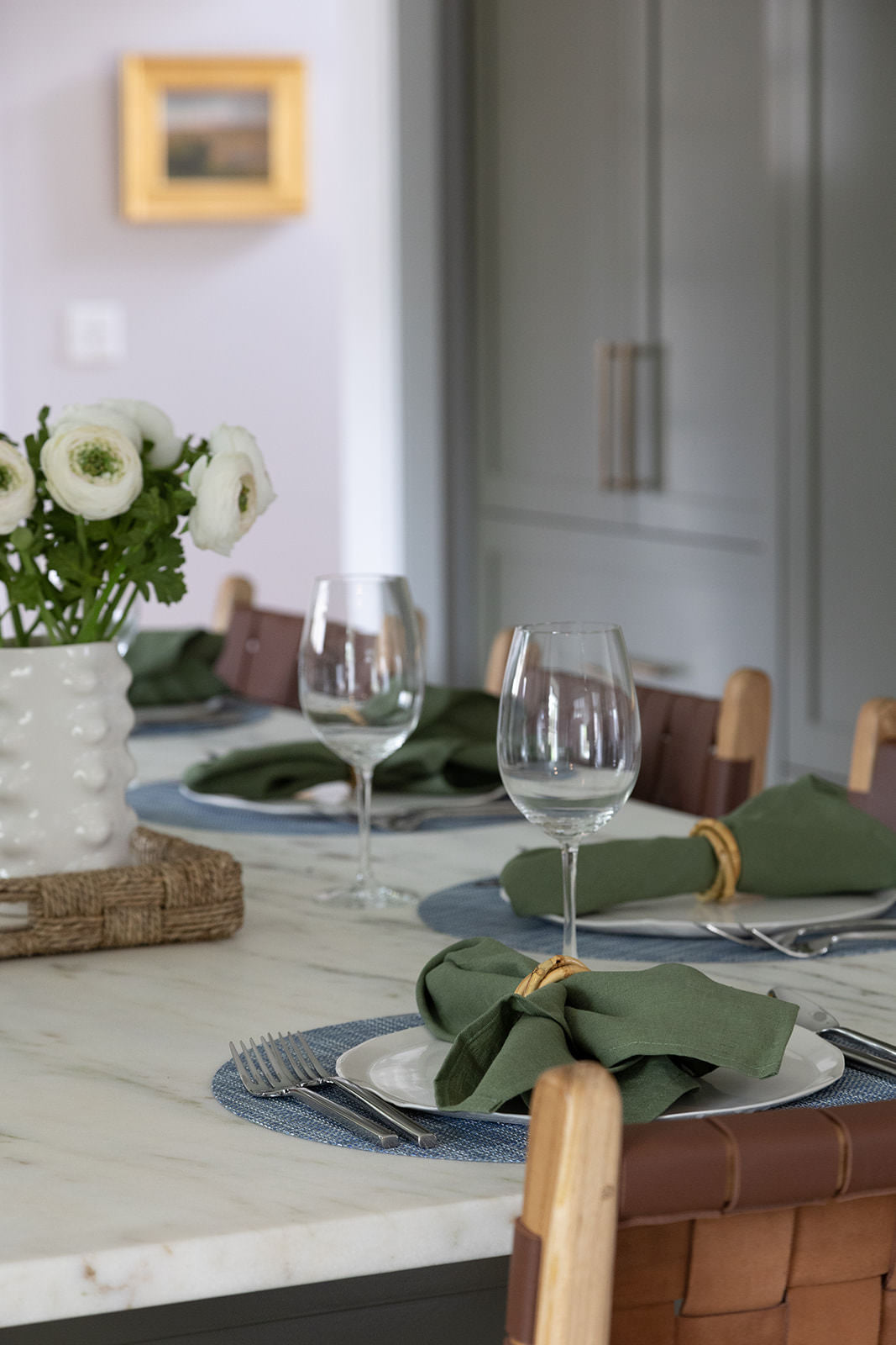 Kitchen island set for dining with green kitchen cabinets in background