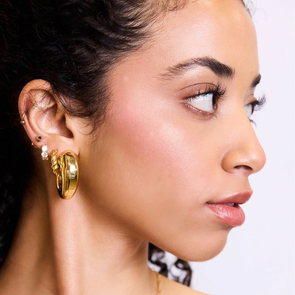 Woman looking to the side with lots of earings at Addison West.