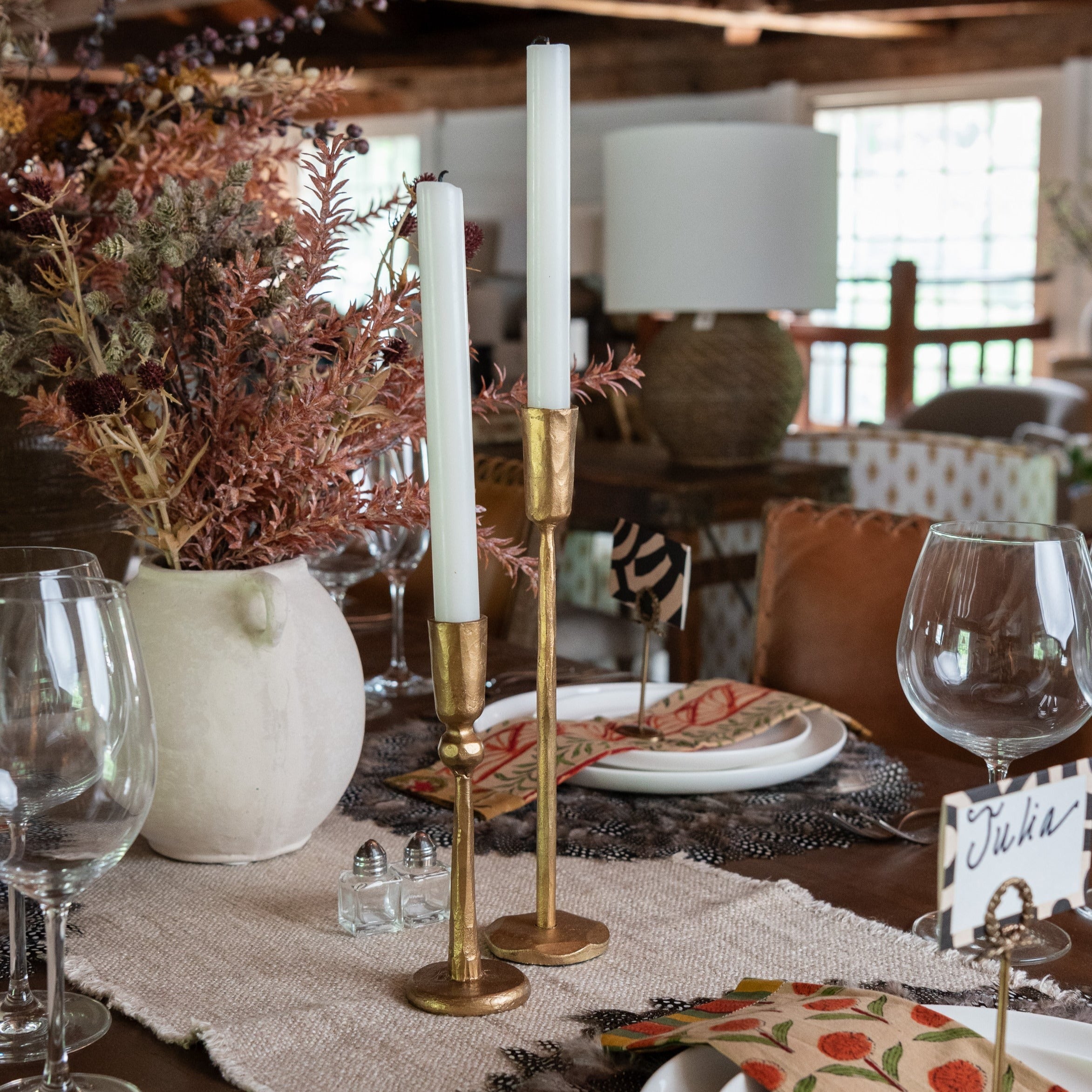 Gold taper candle holders on a dining table at Addison West