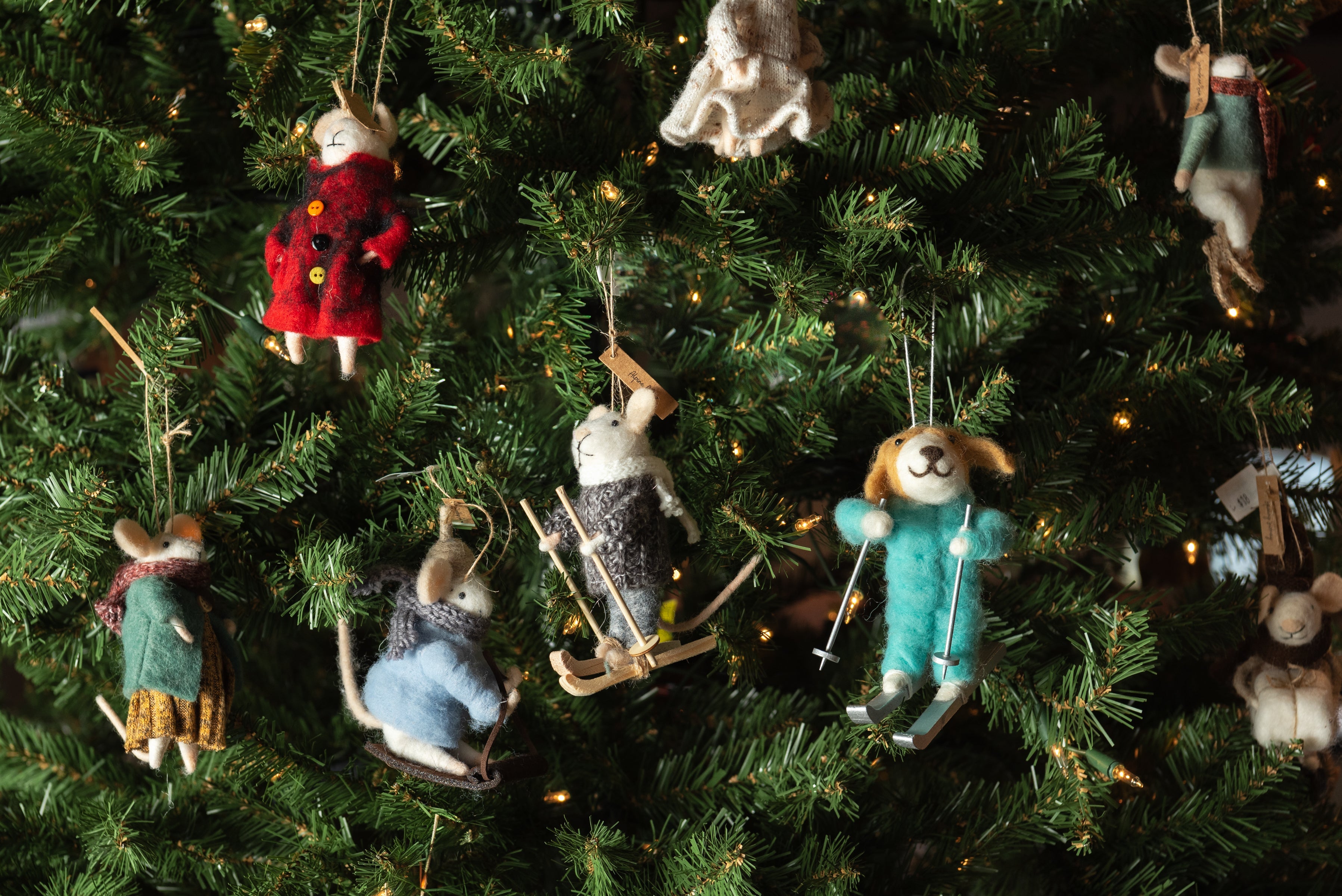 Collection of felted animal holiday ornaments on a tree at Addison West
