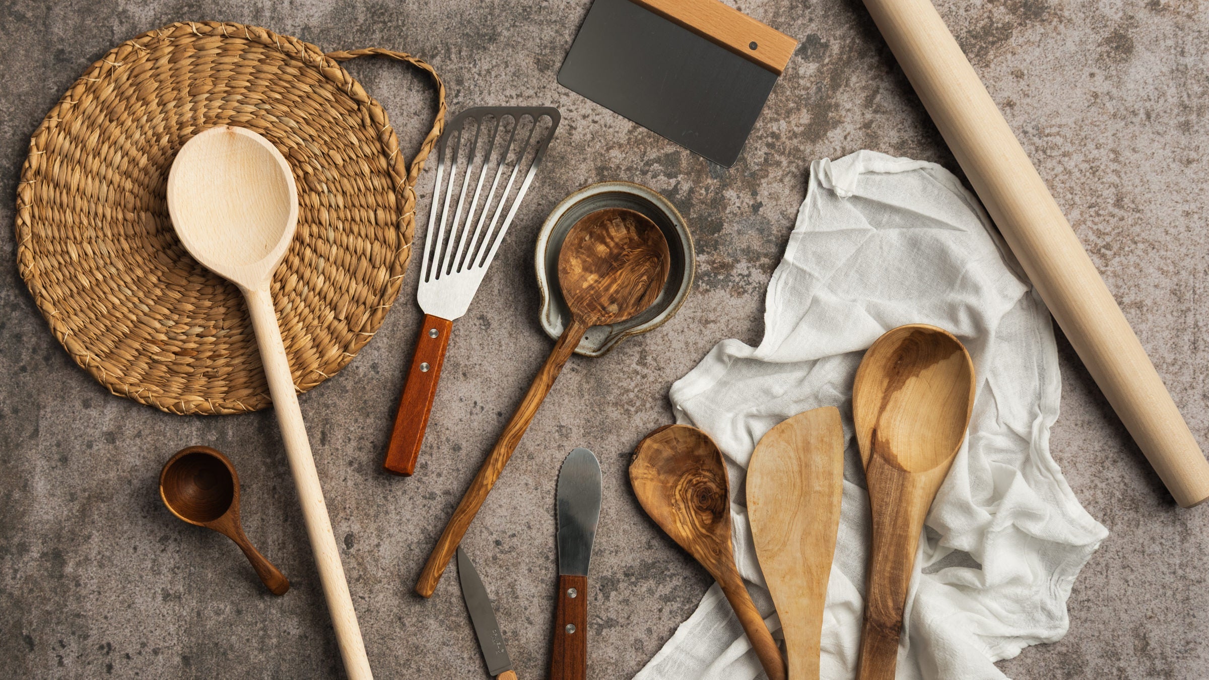 Collection of kitchen tools and utensils on a grey background at Addison West