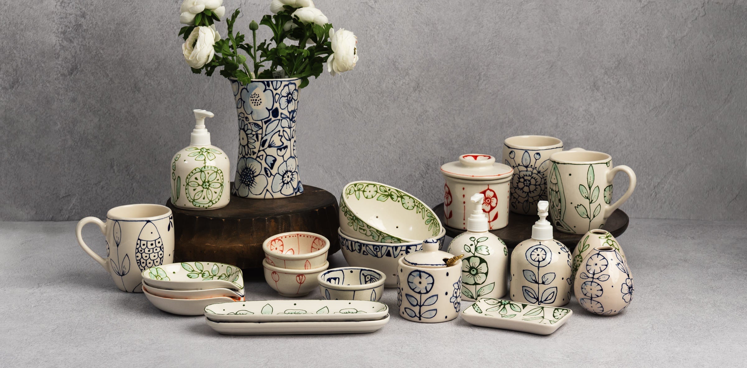 Collection of colorful and whimsical Stephanie Verdun ceramics on a grey background at Addison West