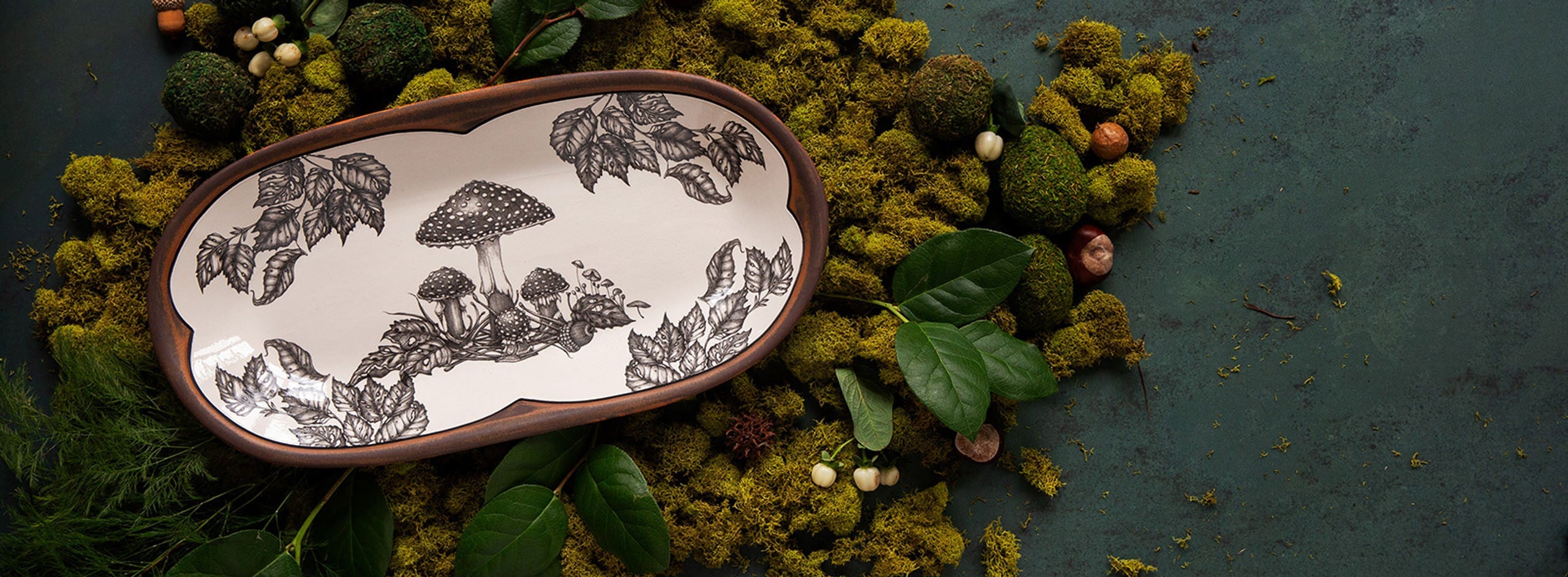 Laura Zindel handmade ceramics with mushroom design on a green background at Addison West