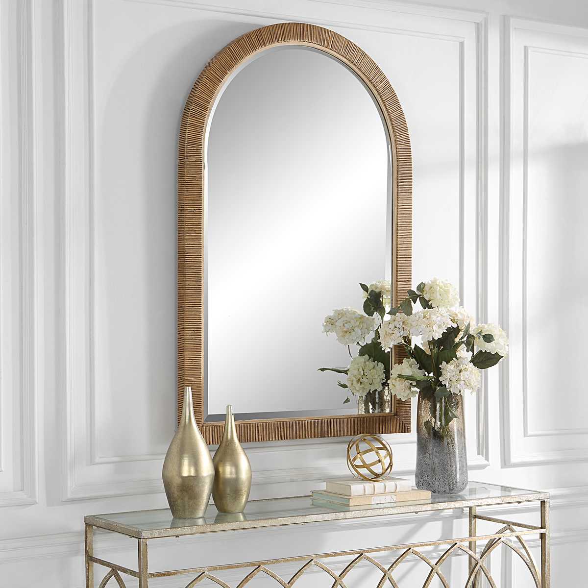 Capridge Arch Accent Mirror on a white wall above a table at Addison West