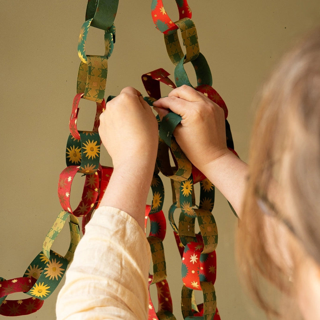 East End Press Festive Paper Chain Kit being hung by a person at Addison West