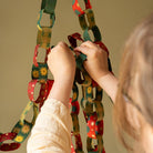 East End Press Festive Paper Chain Kit being hung by a person at Addison West