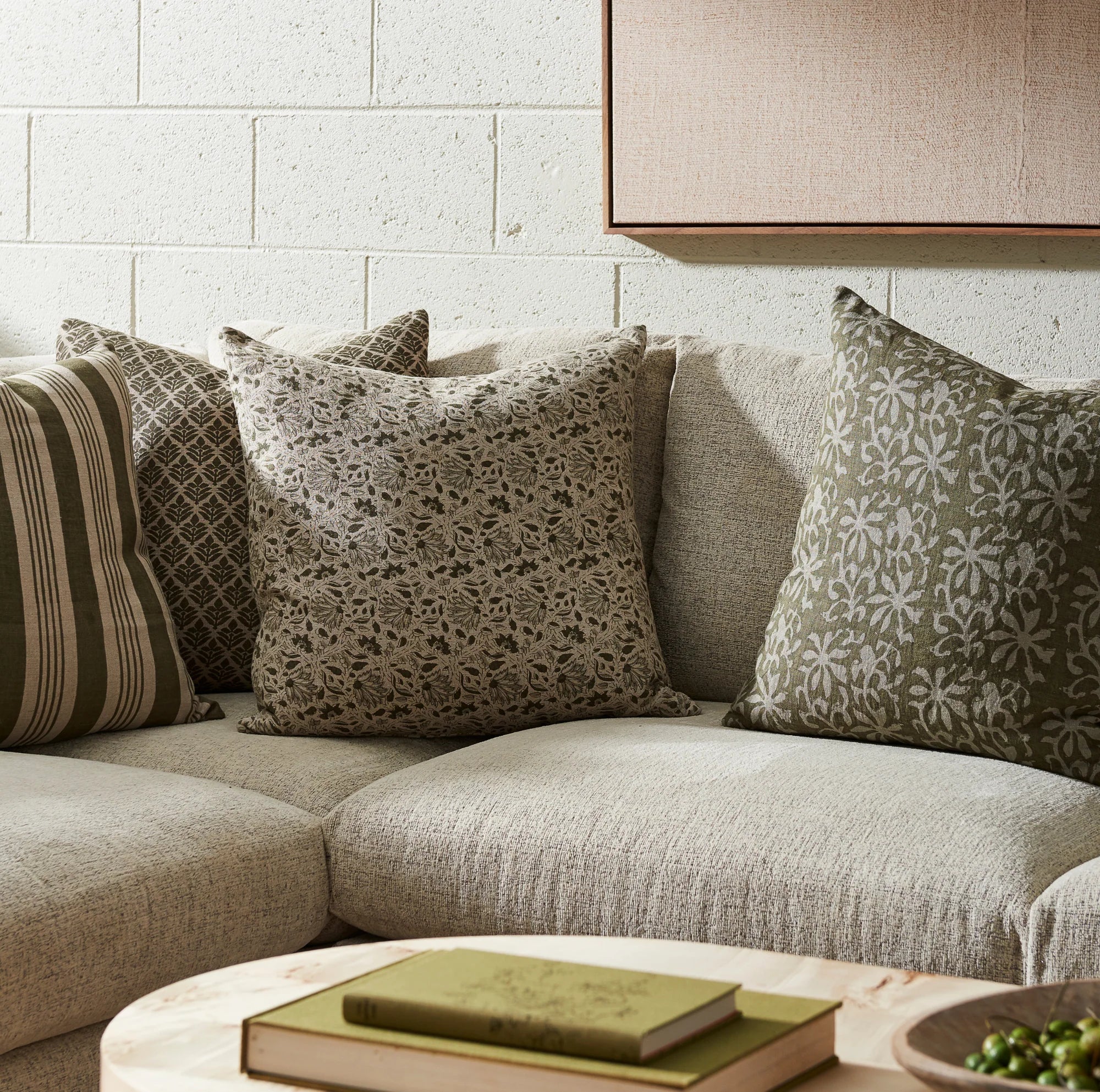 Aisha Green 22" Square Pillow on a sofa  at Addison West