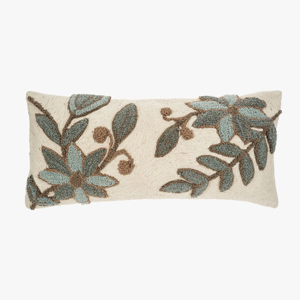 Off white lumbar pillow with embroidered green blue and brown floral pattern on a white background