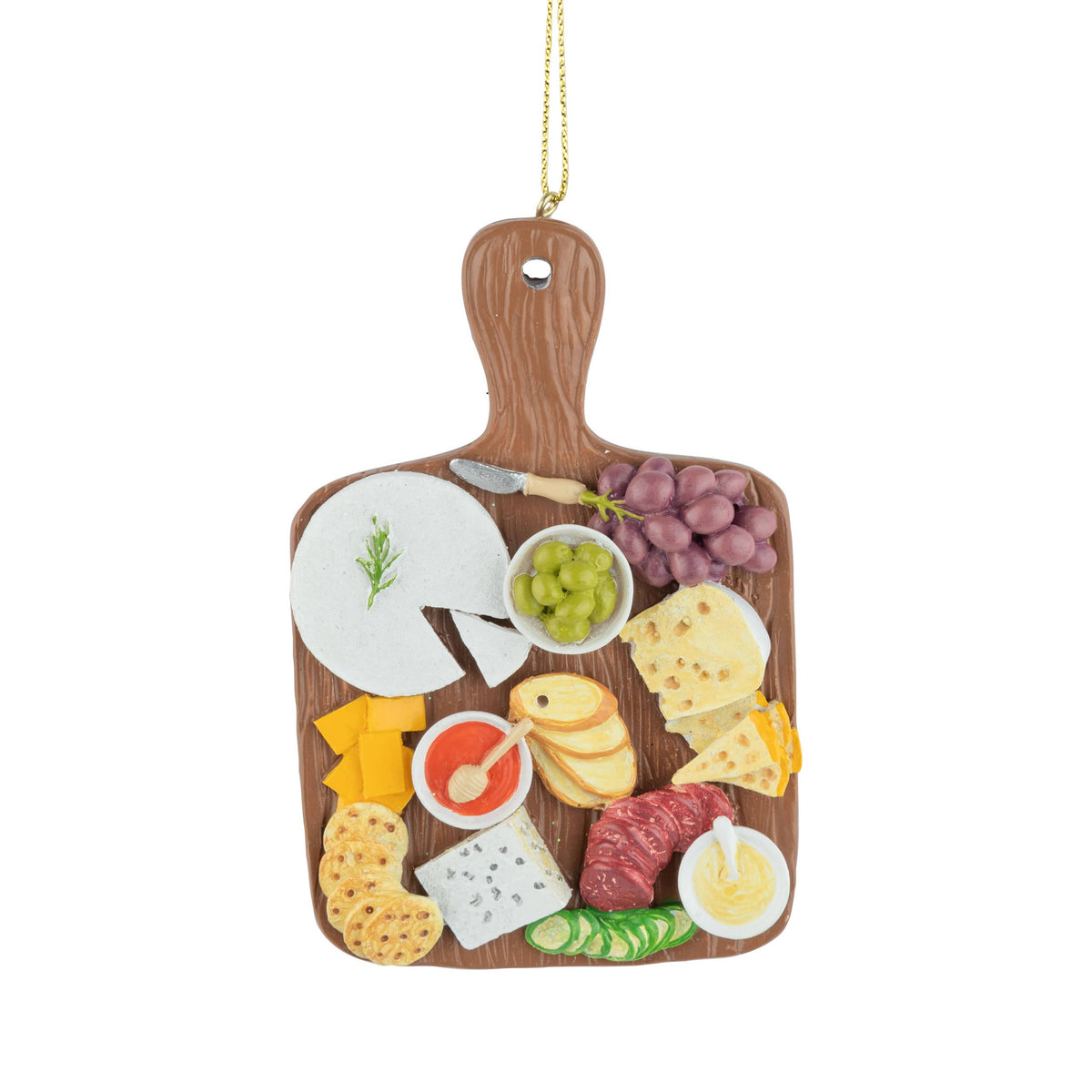 A wooden charcuterie board ornament hanging ornament with a gold hanging string, featuring illustrated food items like cheese, grapes, crackers, salami, and dips on a white background.