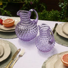 Hobnail Glass Pitcher in Lilac Bloom on a table at Addison West