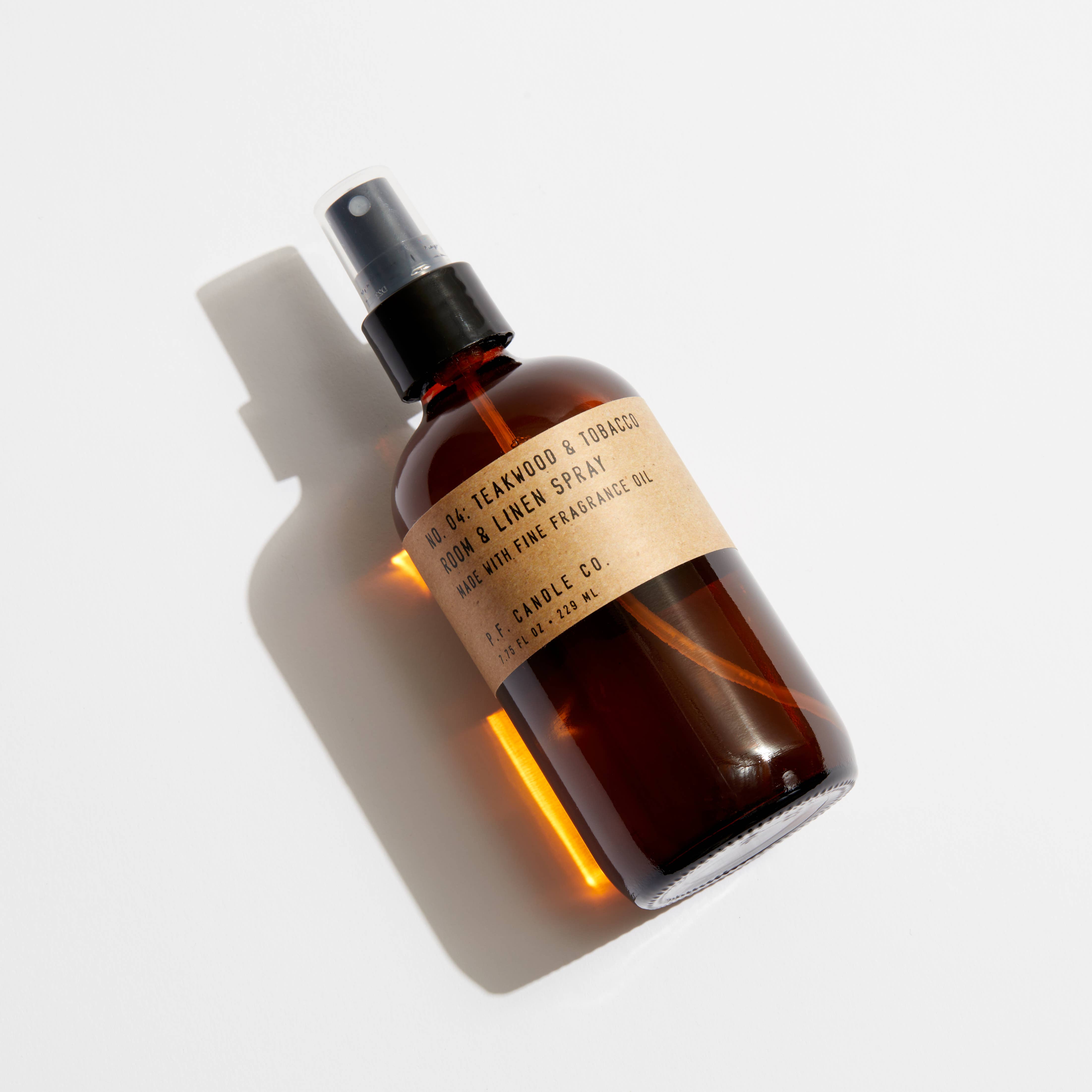 Brown PR Candle Room and Linen spray bottle with a label on a light gray background