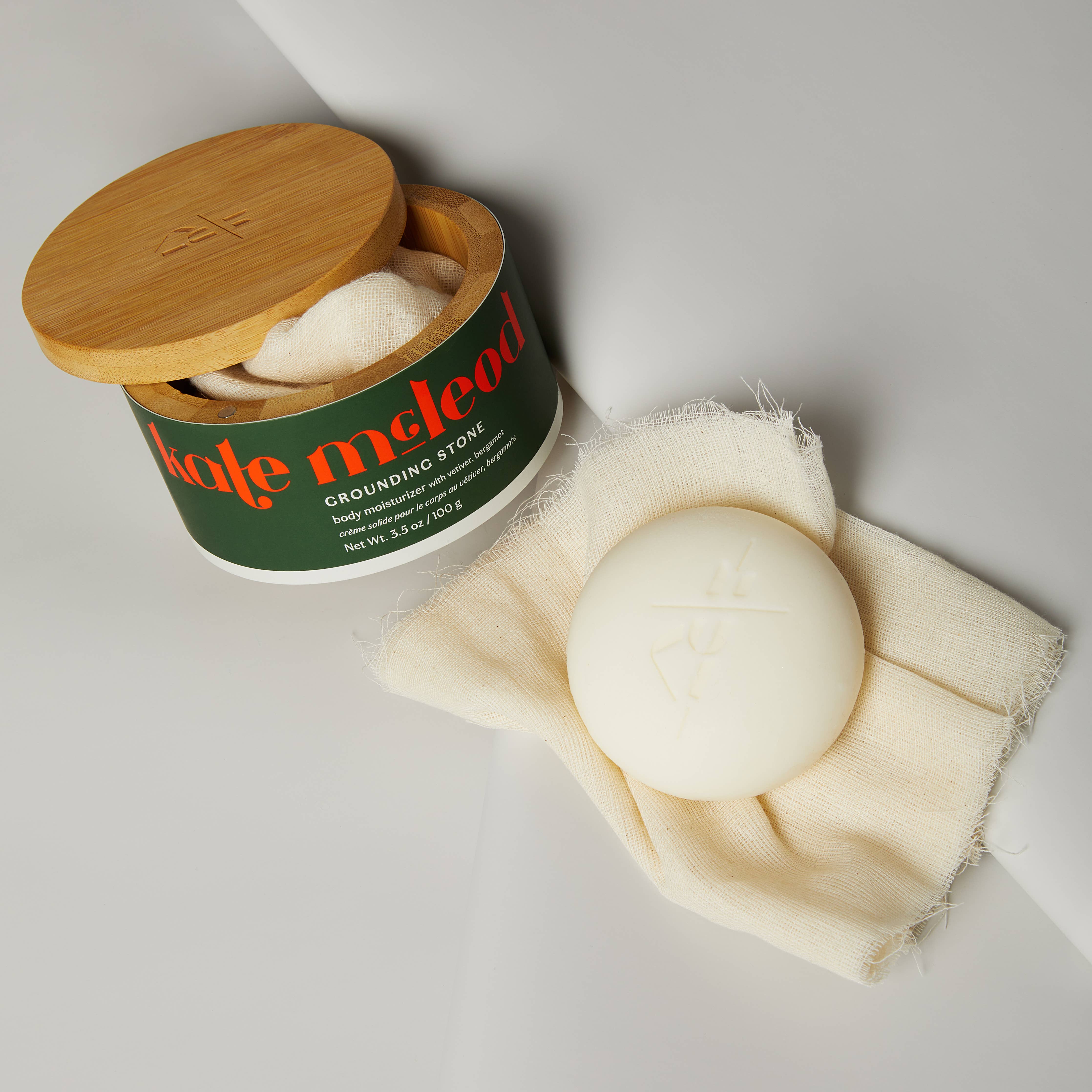 Kate Mcleod Grounding Stone Deep Moisturizing Lotion Bar on a grey background