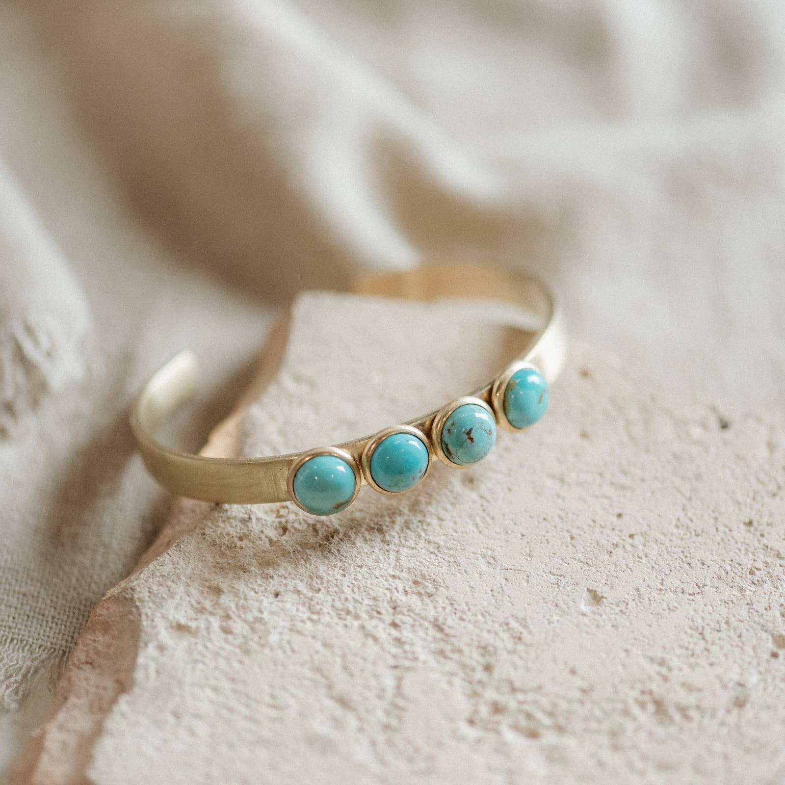 Commonform Bridger Cuff in Turquoise on textured background at the Addison West.