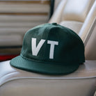 Warren Farm League Ballcap in Green Mountain State on a grey car seat at Addison West