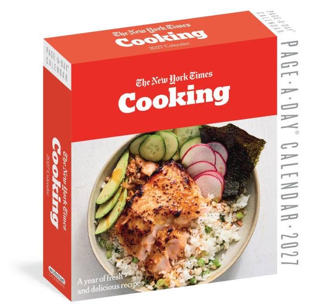The New York Times Cooking 365-recipe calendar box shown at a slight angle, featuring a bright red top and side panels, white text, and a photo of salmon over rice with sliced cucumbers and radishes on the front.