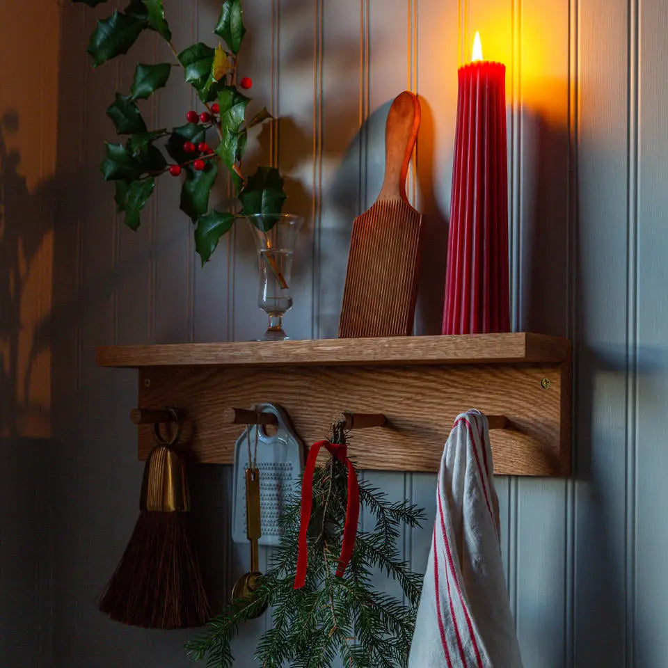Greentree 8" Petite Pillar Candle in Bittersweet on a shelf with holiday decorations at Addison West