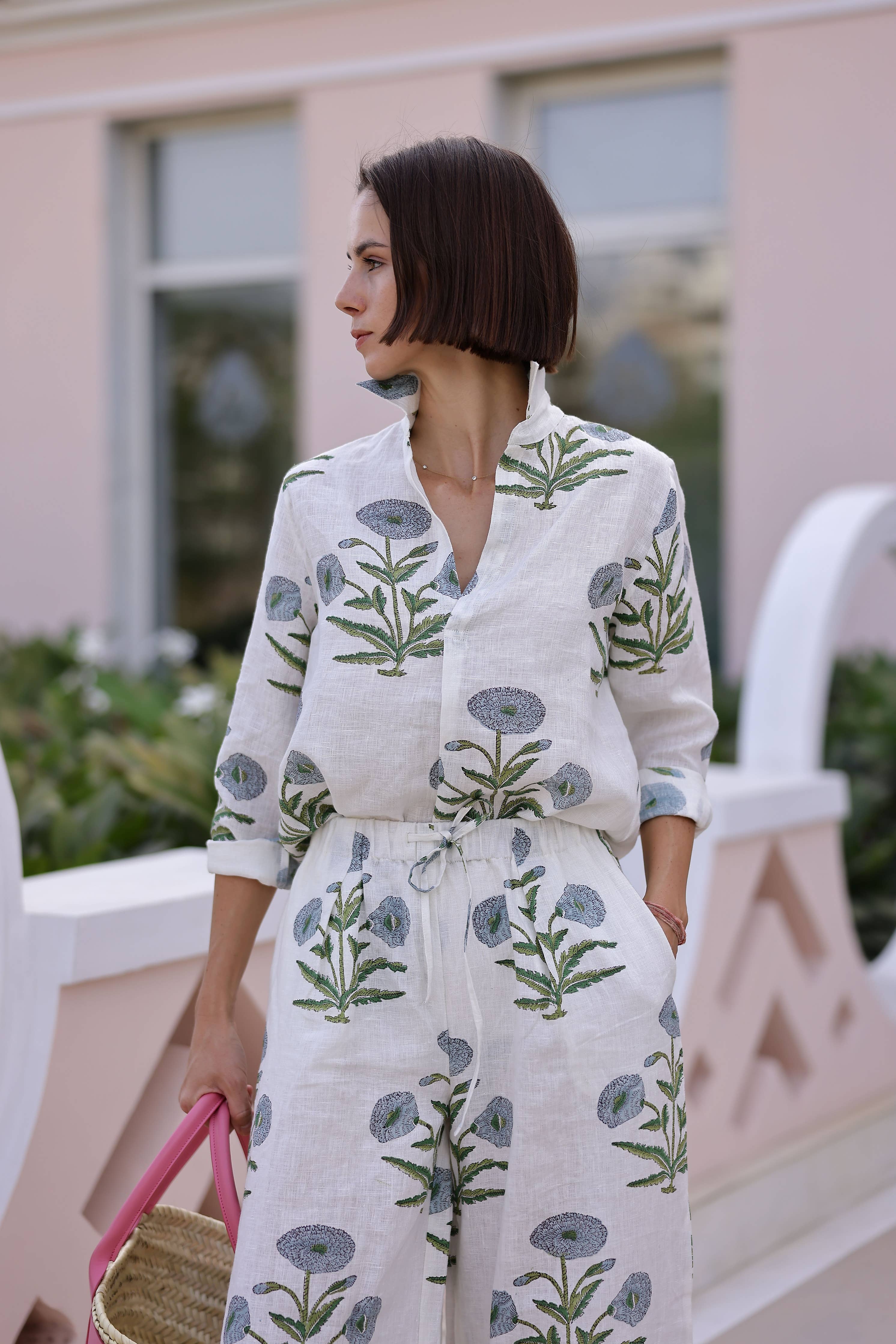 Woman wearing a floral maison marigold montecito top standing outdoors with a blurred background