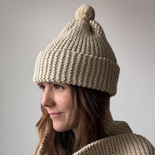 Knitting Craft Kit: Classic Pom Beanie in Sand on a beige background at Addison West