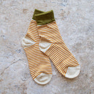 Stripe Socks in Olive and Oatmeal on a beige background at Addison West