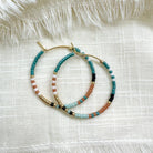 Ocean Breakup Bright Beaded Hoop Earrings in Blue on white background at the Addison West.