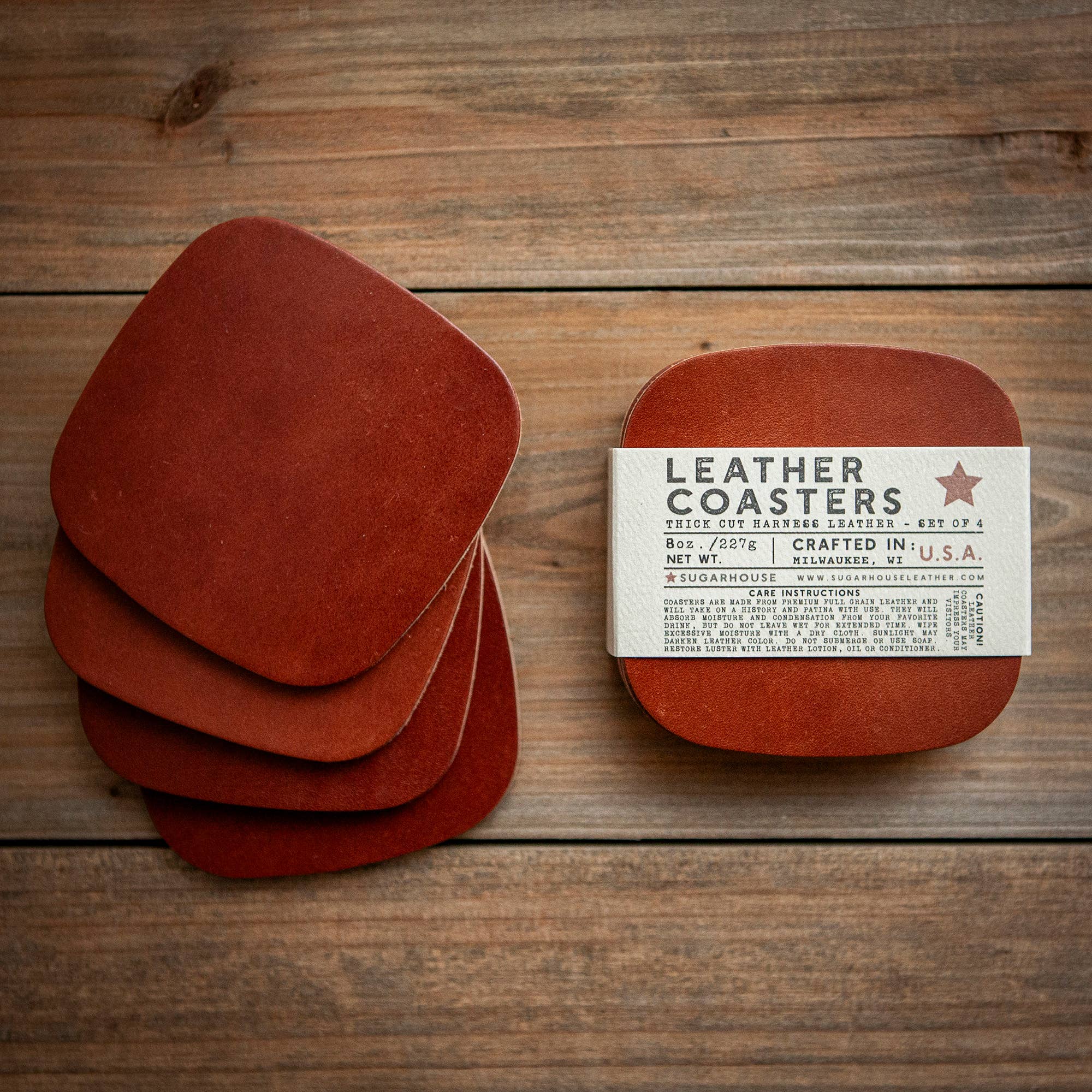 Set of brown leather coasters with a label on a wooden surface