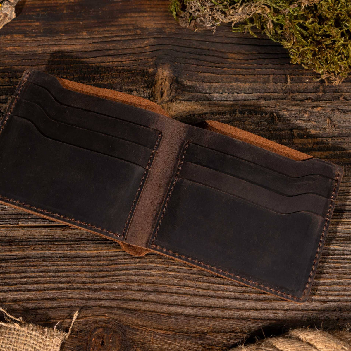 Leather Wallet Bifold Wallet in Dark Brown on a wood table at Addison West