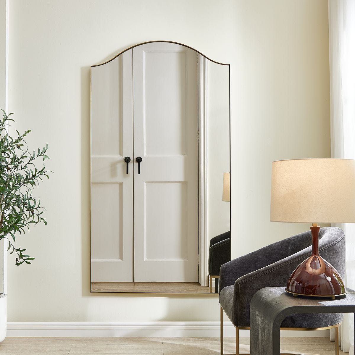 Mallorin Arch Full Length Mirror on a white wall in a living room at Addison West