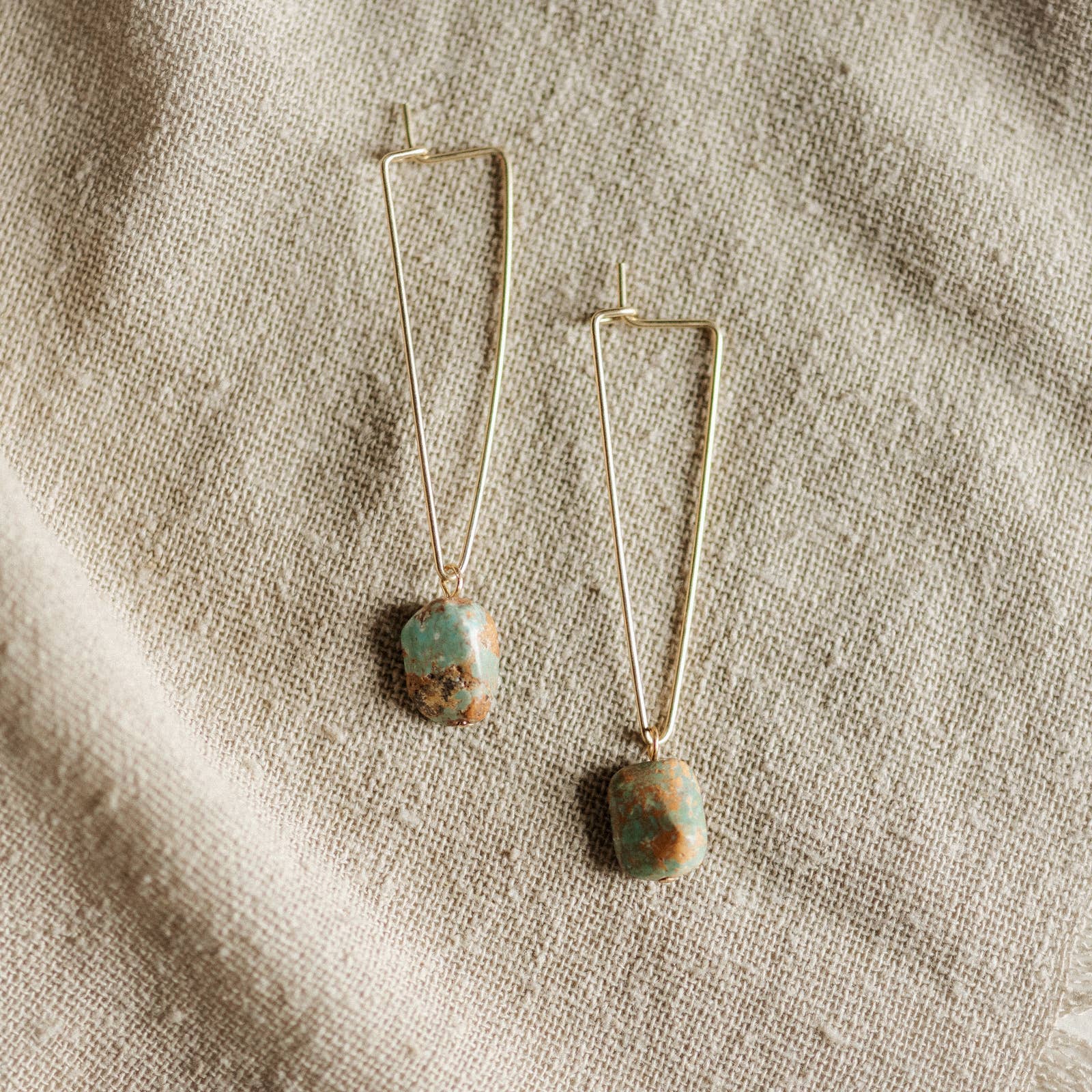 Commonform Aurora Earrings in Turquoise on textured background at the Addison West.