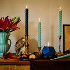 Greentree 10" Rope Taper Candle in Blue Slate in a candleholder on a table at Addison West