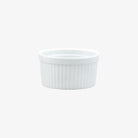 Small white ramekin with ridges on a white background