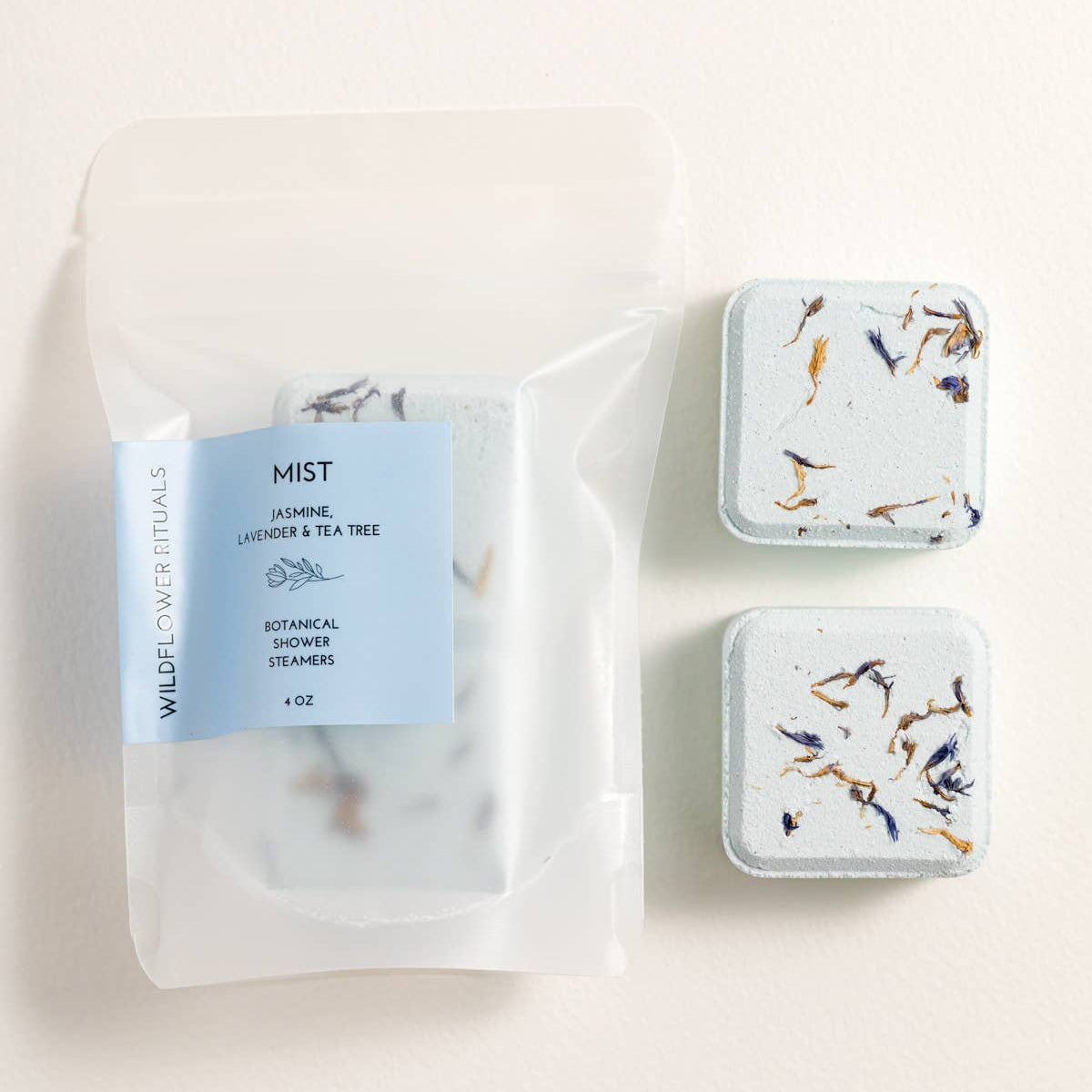 Three small containers with labels on a light background
