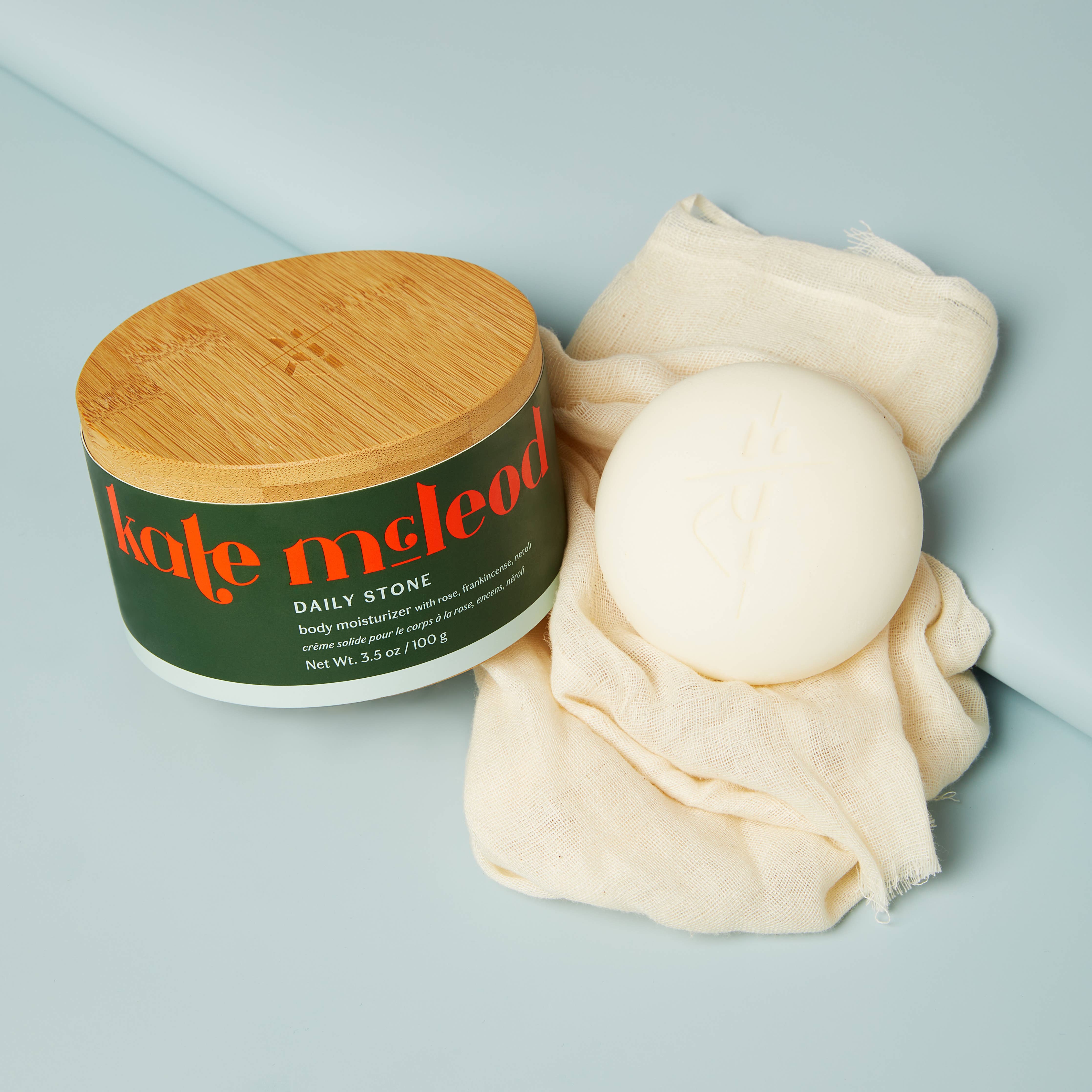 Kate McLeod Daily Stone Deep Moisturizing Lotion Bar on a blue background